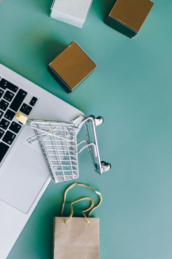 Online selling: laptop, shopping cart, and packages on a desk